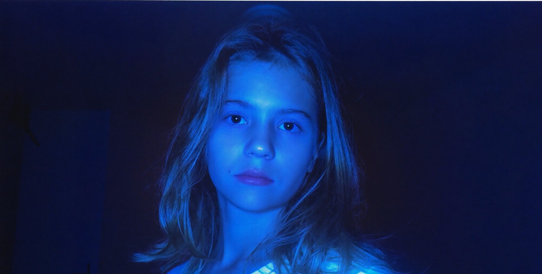 A student lit by blue screen light